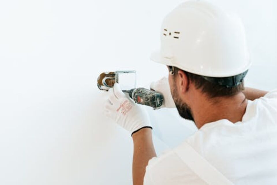 Electrician installing or servicing a wall electrical fixture